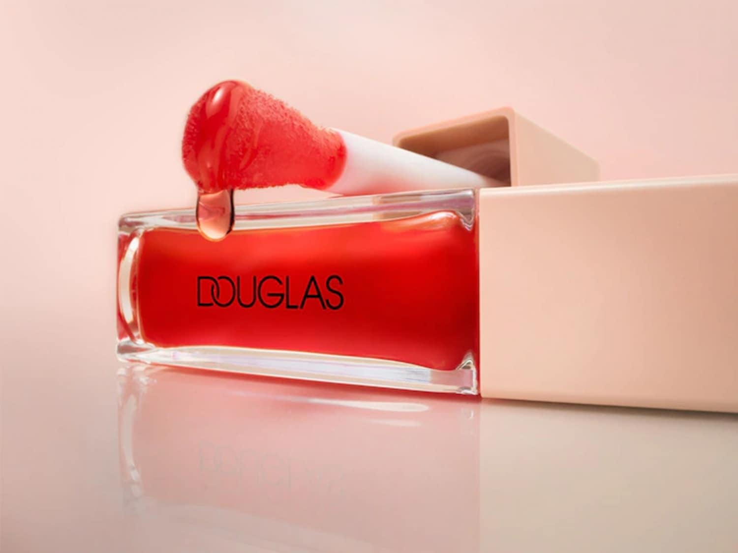 Ecco il lucidalabbra Douglas dal colore rosso acceso, con applicatore e confezione beige, per labbra sempre perfette.