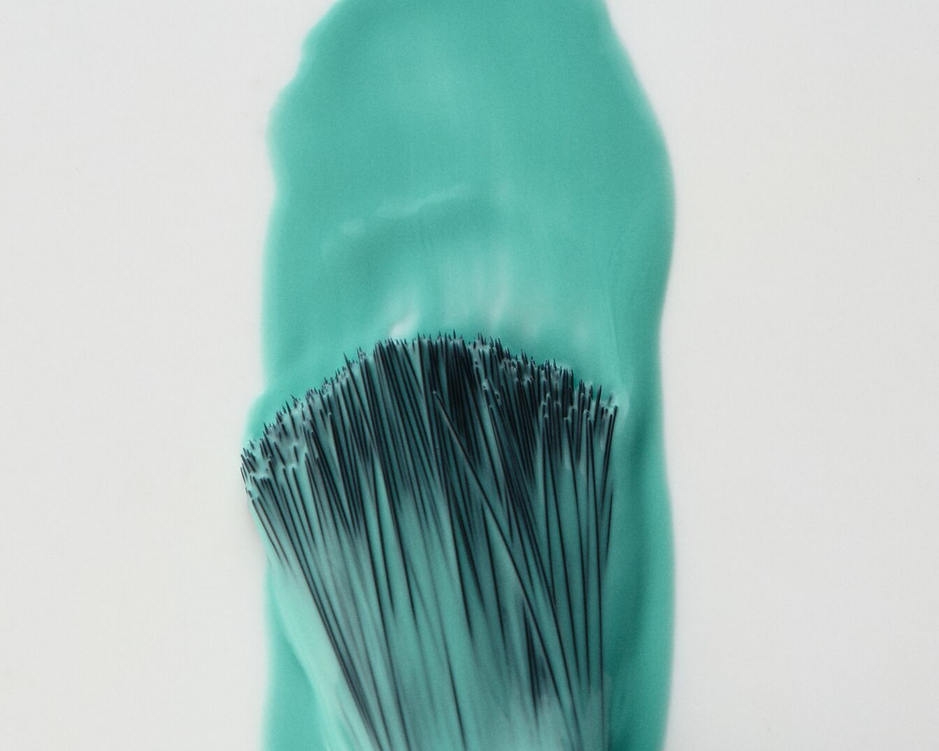 Ecsetvonás türkizkék festékkel, amely kiemeli a színt és a textúrát.