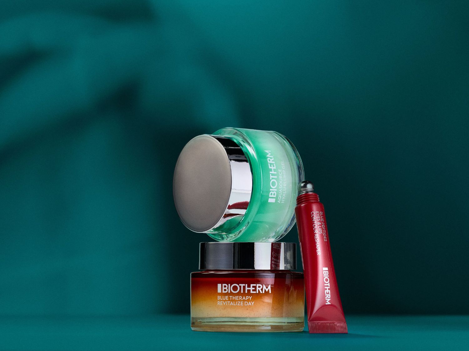 A Biotherm termékek: egy zöld Aquasource Hyalu-Plump Gel, egy narancssárga Blue Therapy Revitalize Day krém és egy piros Blue Peptides szem- és ajakápoló.