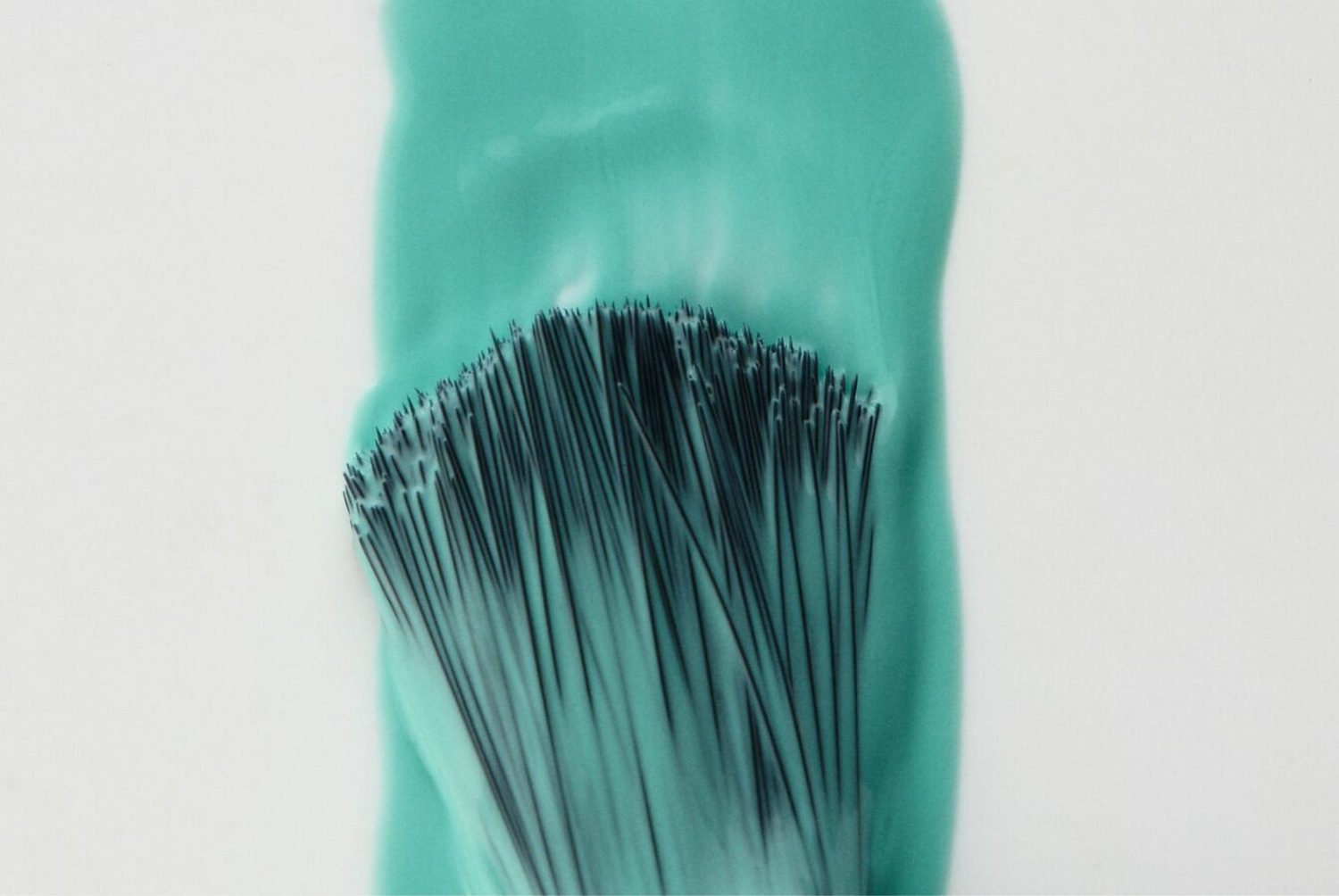 Ecsetvonás türkizkék festékkel, amely kiemeli a finom ecsetvonásokat.