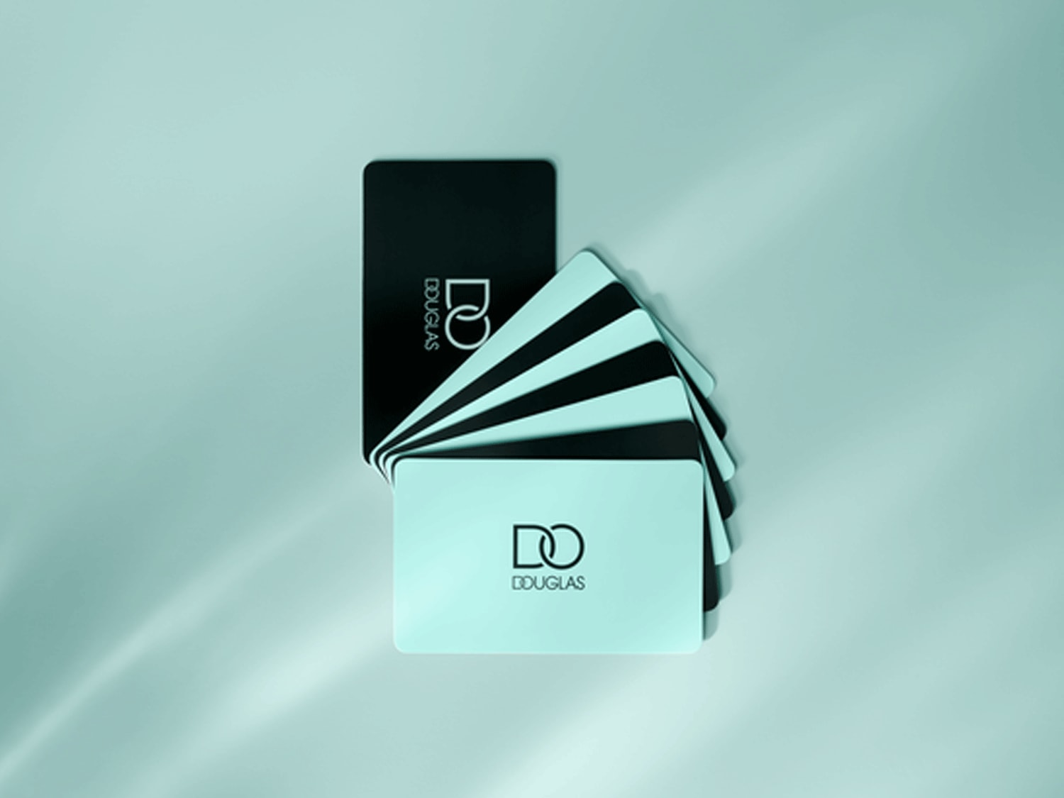 Juodos ir šviesiai žalios spalvos „Douglas“ dovanų kortelės išdėstytos vėduoklės pavidalu ant šviesiai žalios spalvos fono.