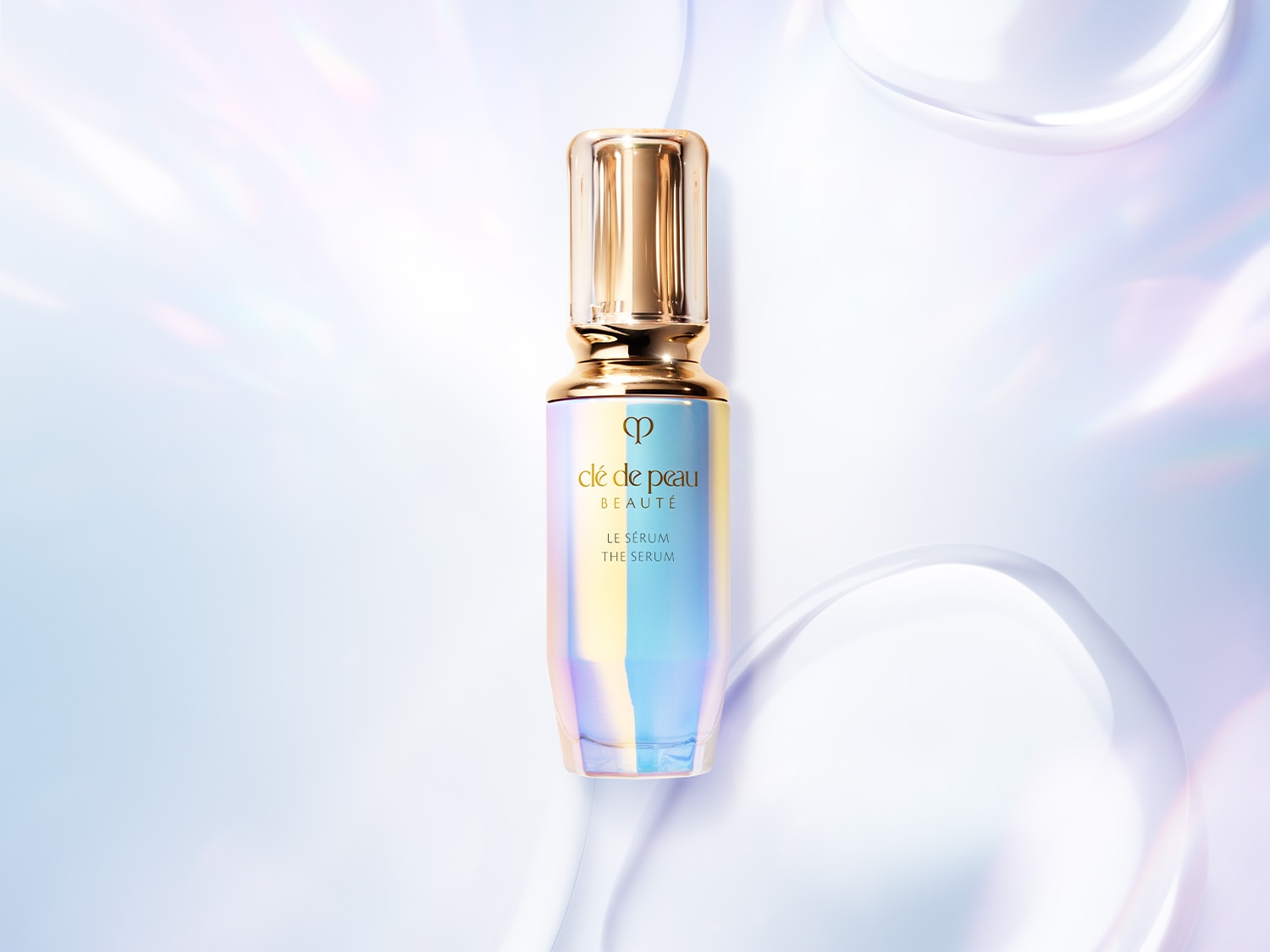 Das Clé de Peau Beauté Le Sérum in einer schillernden Flasche mit goldenem Verschluss, die eine luxuriöse Hautpflegeessenz verspricht.