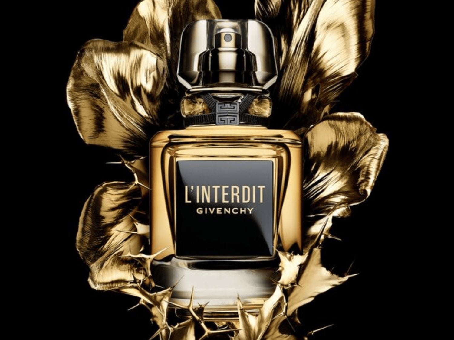 A Givenchy L'Interdit arany színű parfümös üvege fekete címkével, arany virágokkal körülvéve, luxust és kifinomultságot sugároz.