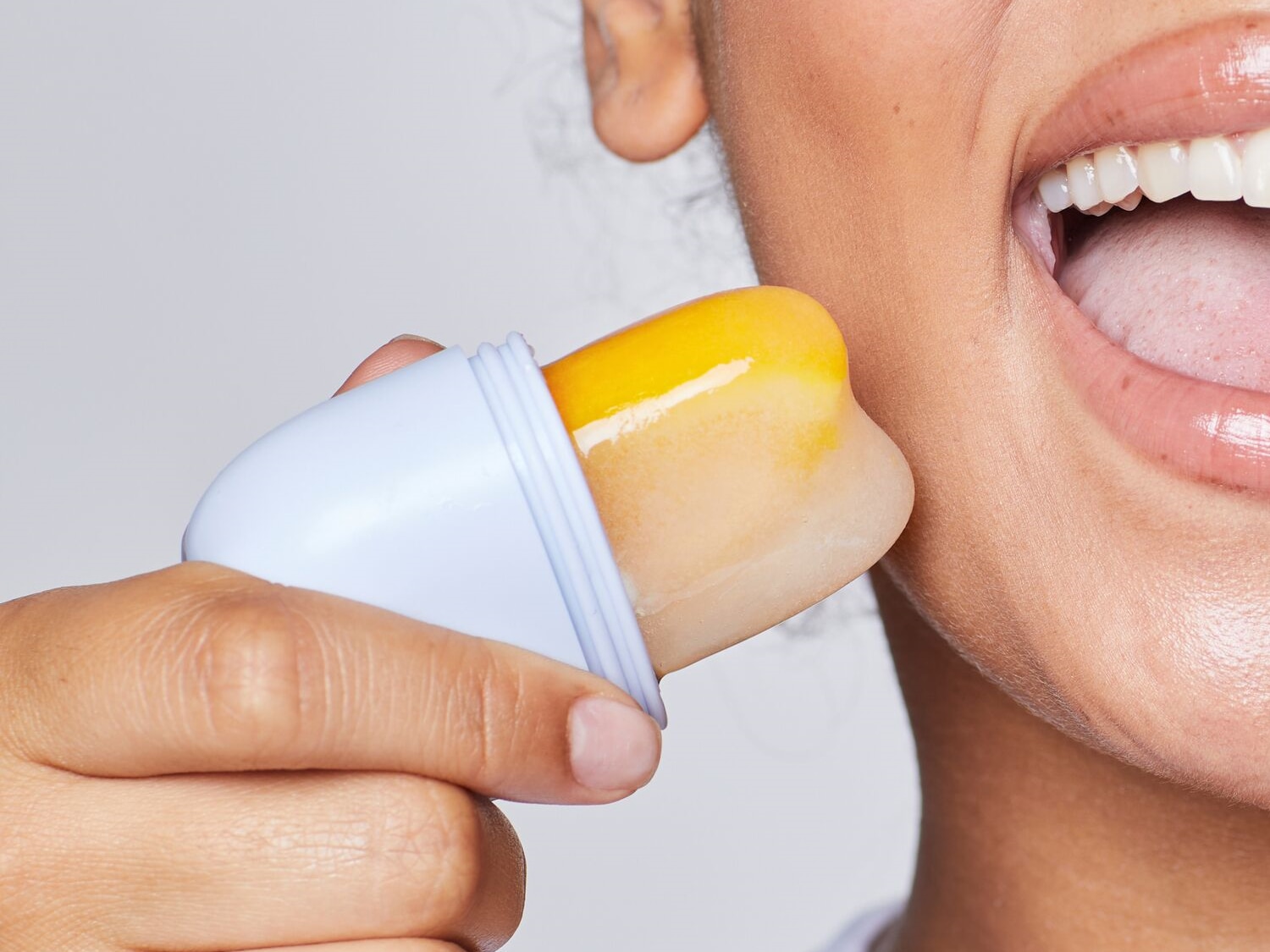 Gezichtsmassage met een ijsblokje in een blauwe houder voor een verfrissende en revitaliserende ervaring.