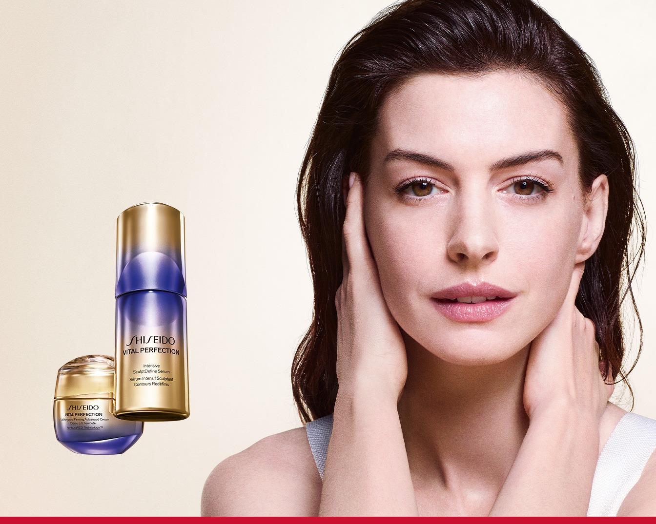 Een vrouw met bruin haar en een witte top houdt haar handen tegen haar gezicht, met naast haar twee Shiseido Vital Perfection producten: een goudkleurige en paarse serumfles en een bijpassende crème in een potje.