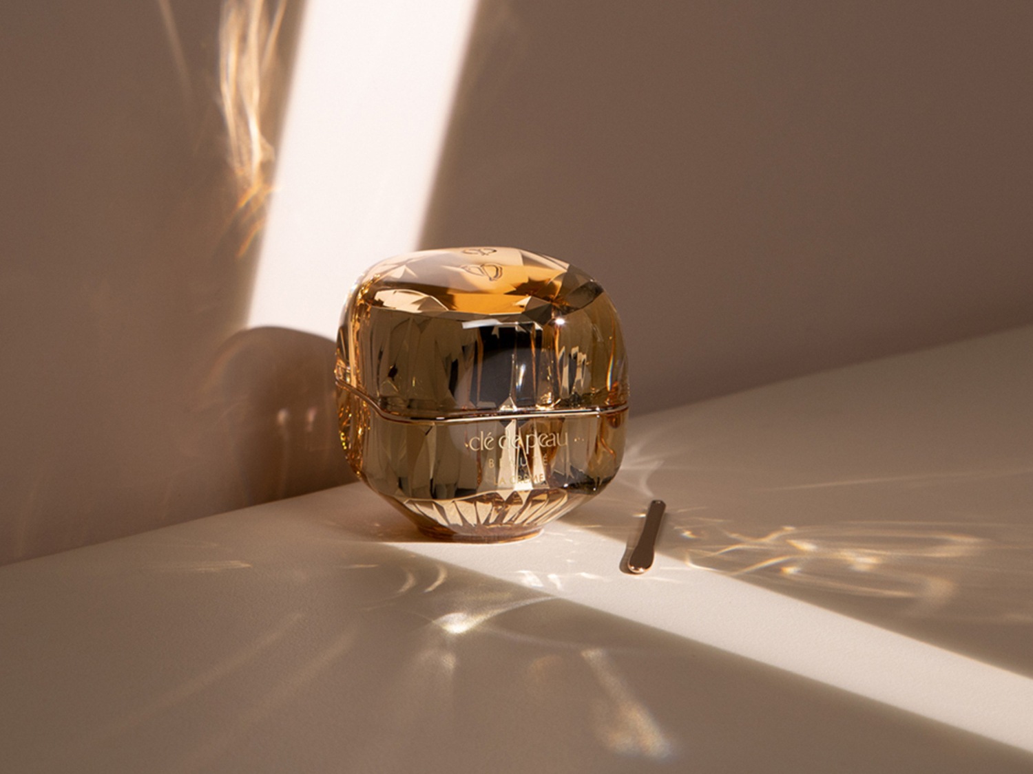 Découvrez l'élégance avec ce pot doré de Clé de Peau, un écrin de beauté qui illumine votre peau.