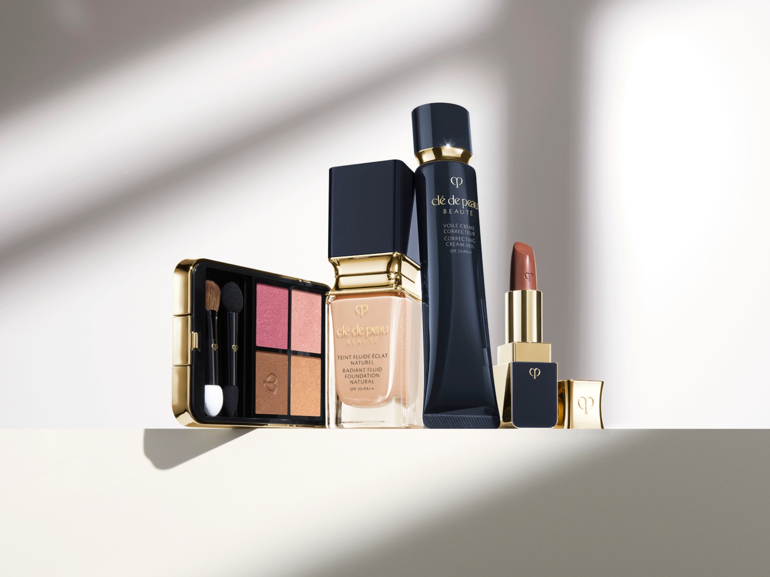 Découvrez la collection de maquillage Clé de Peau Beauté, comprenant une palette de fards à joues, un fond de teint éclatant, un voile crème correcteur et un rouge à lèvres élégant.