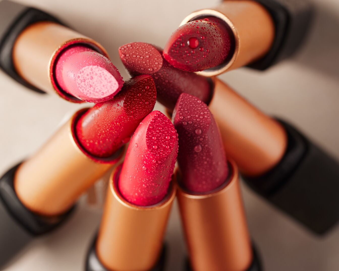 Découvrez un éventail de rouges à lèvres aux teintes rosées et rouges, parés de gouttelettes pour un effet frais et séduisant.