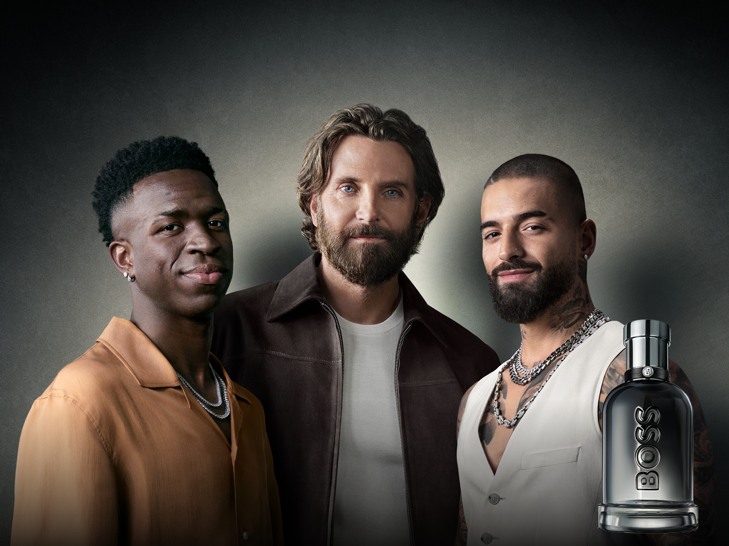 Tres hombres posan con una botella de perfume BOSS, mostrando elegancia y estilo moderno.