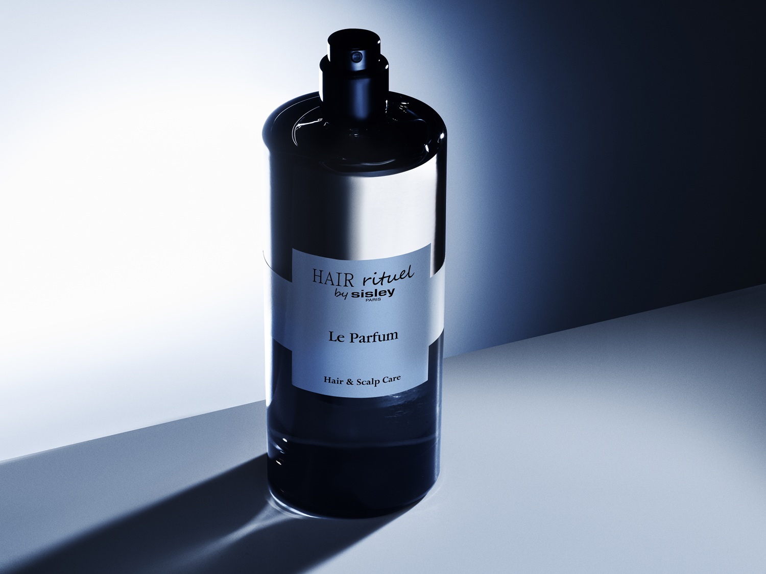 Czarna, błyszcząca butelka Hair Rituel by Sisley Le Parfum do pielęgnacji włosów i skóry głowy.