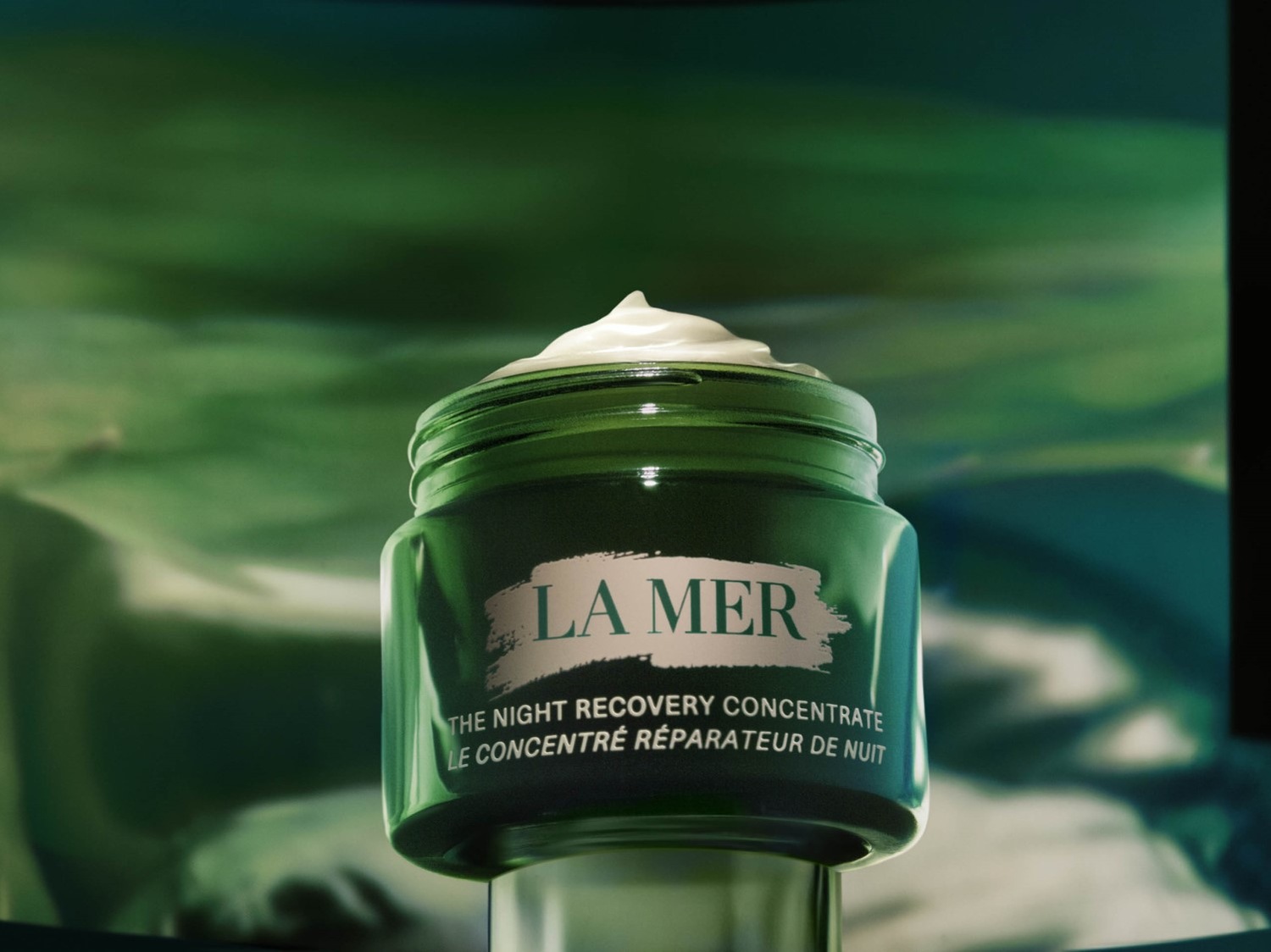 Szklany słoik La Mer w odcieniach zieleni zawiera krem The Night Recovery Concentrate, który intensywnie nawilża i regeneruje skórę podczas snu.