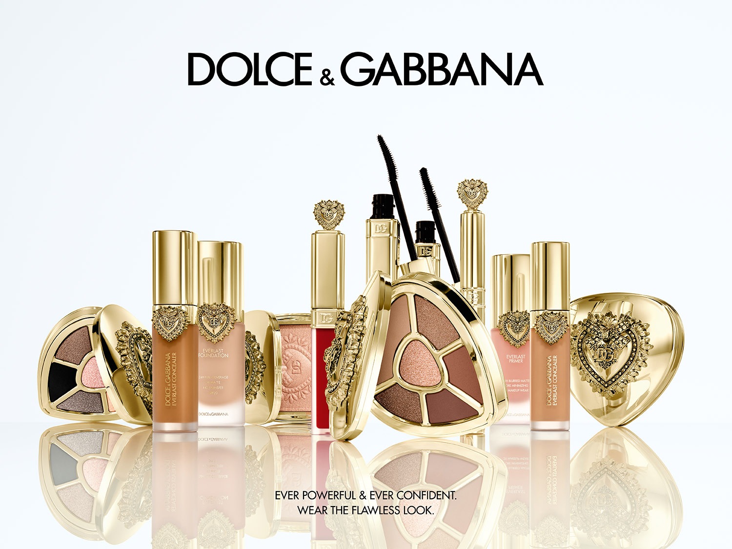 Kolekcja kosmetyków Dolce & Gabbana w złotych opakowaniach, w tym podkład, korektor, baza, tusz do rzęs i paleta cieni do powiek. Bądź silna i pewna siebie, stwórz nieskazitelny wygląd