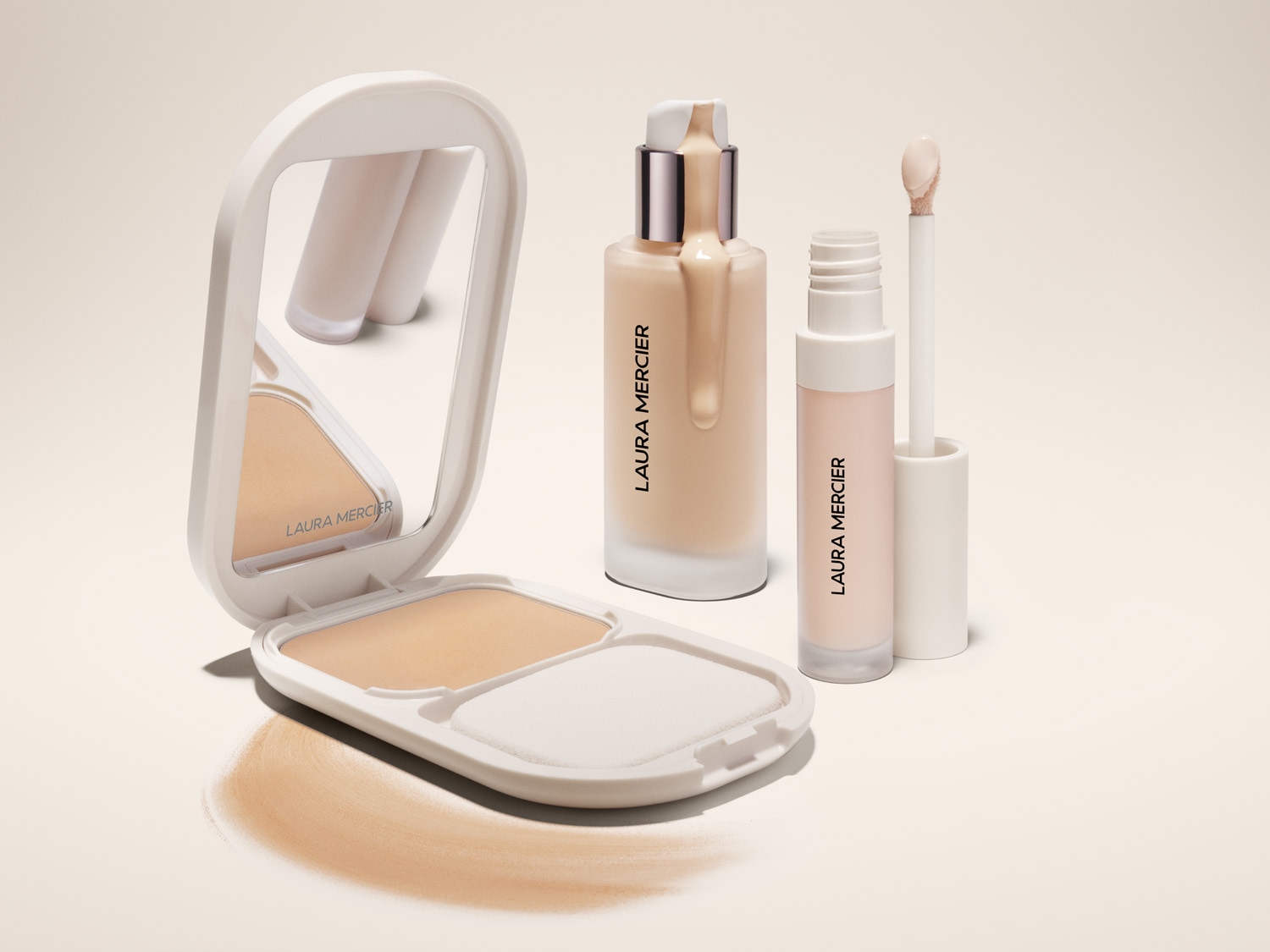A Laura Mercier sminktermékek kollekciója: púderes alapozó tükörrel, folyékony alapozó és korrektor világos bézs árnyalatokban.