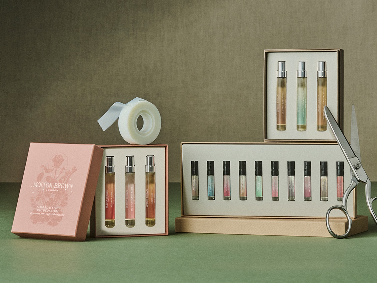 A Molton Brown London illatminták elegáns készletei, köztük a Floral & Spicy Eau de Parfum Discovery Set, rózsaszín dobozban, virágos dizájnnal.