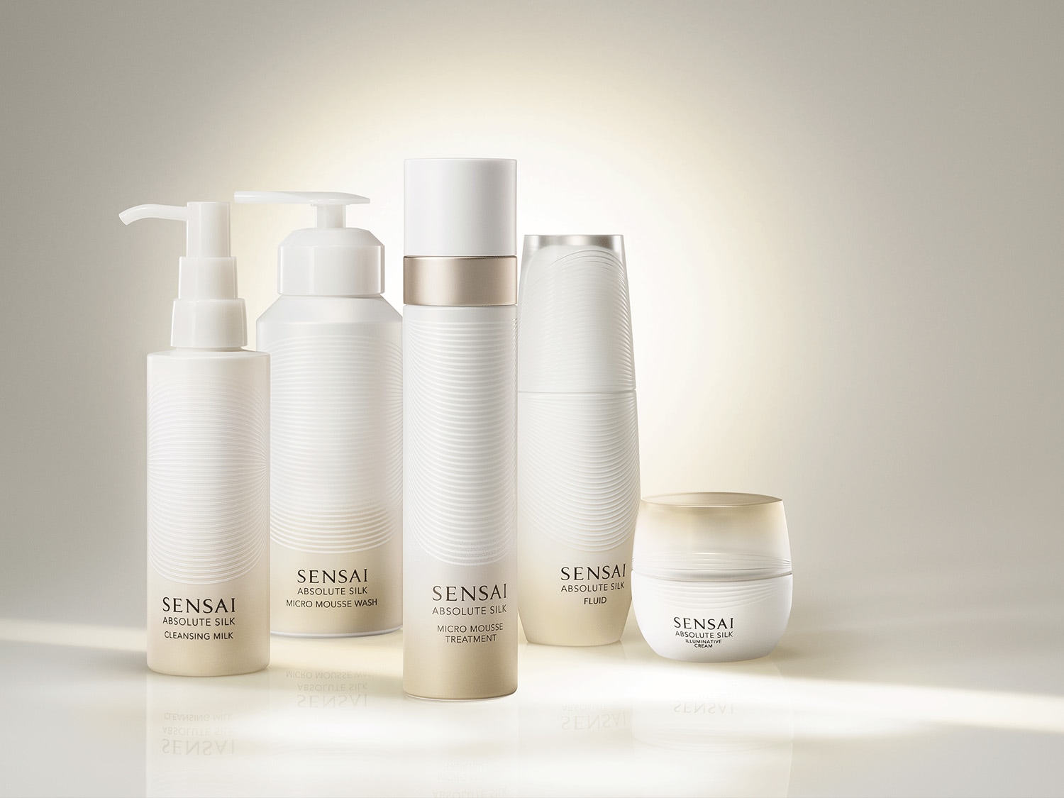 A Sensai Absolute Silk termékcsaládja: arctisztító tej, mikrohabos mosó, mikrohabos kezelés, fluid és illuminative krém elegáns, fehér csomagolásban.