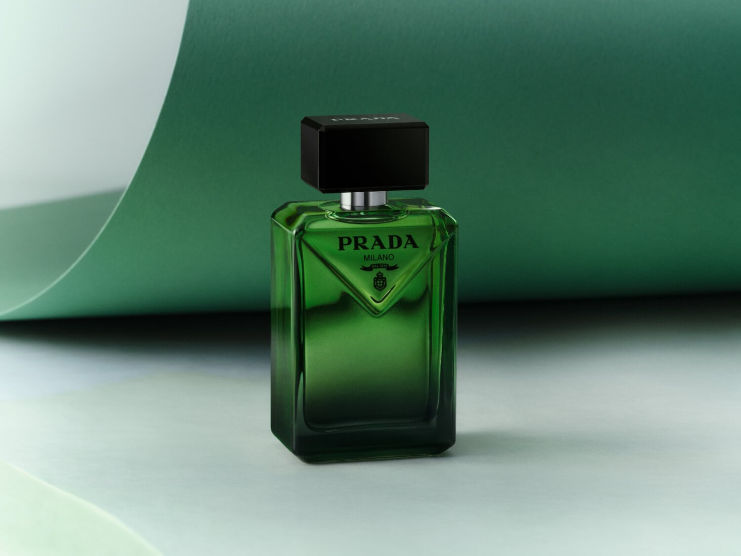 Prada Milano Duft in einem grünen Glasflakon mit einem schwarzen, würfelförmigen Verschluss.