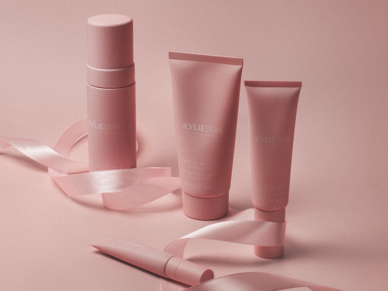 Découvrez les produits KylieSkin dans leurs emballages roses doux, présentés avec un ruban de satin assorti pour une expérience beauté luxueuse.