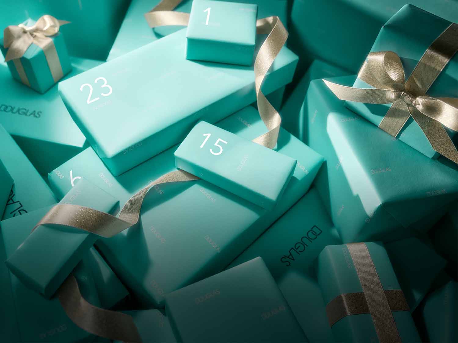 Stos prezentów Douglas w turkusowym papierze, każdy ozdobiony złotą wstążką i oznaczony numerem, tworząc świąteczny kalendarz adwentowy.