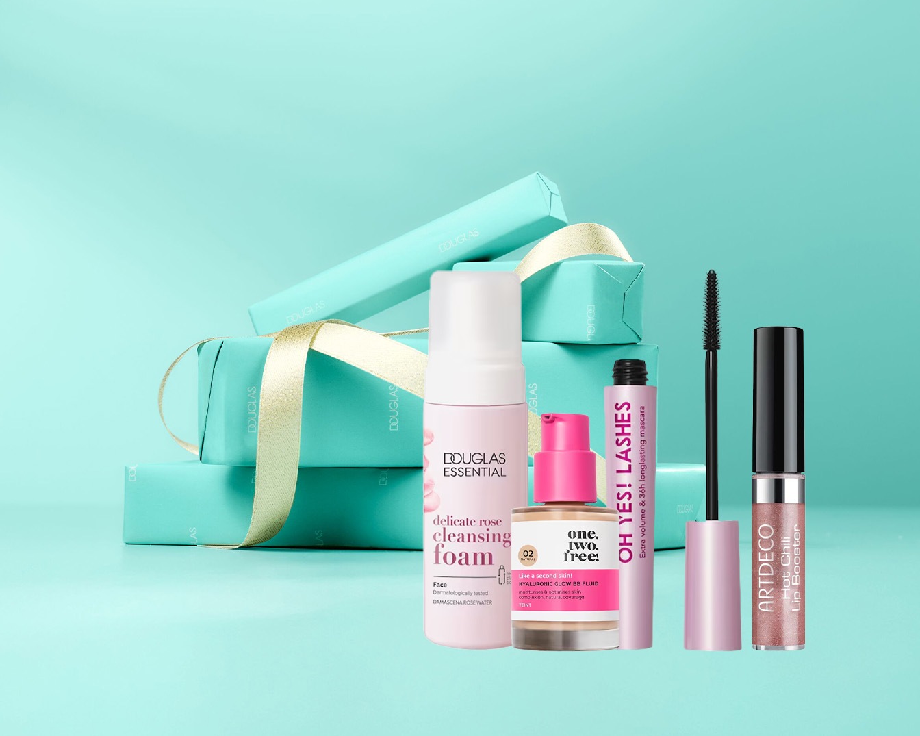 Šviesiai mėlyname fone matomi dovanų rinkiniai, įvyniotas į mėlyną popierių ir perrištas auksiniu kaspinu, taip pat Douglas Essential prausimosi putos, Oh Yes! blakstienų tušas ir Artdeco lūpų blizgis.