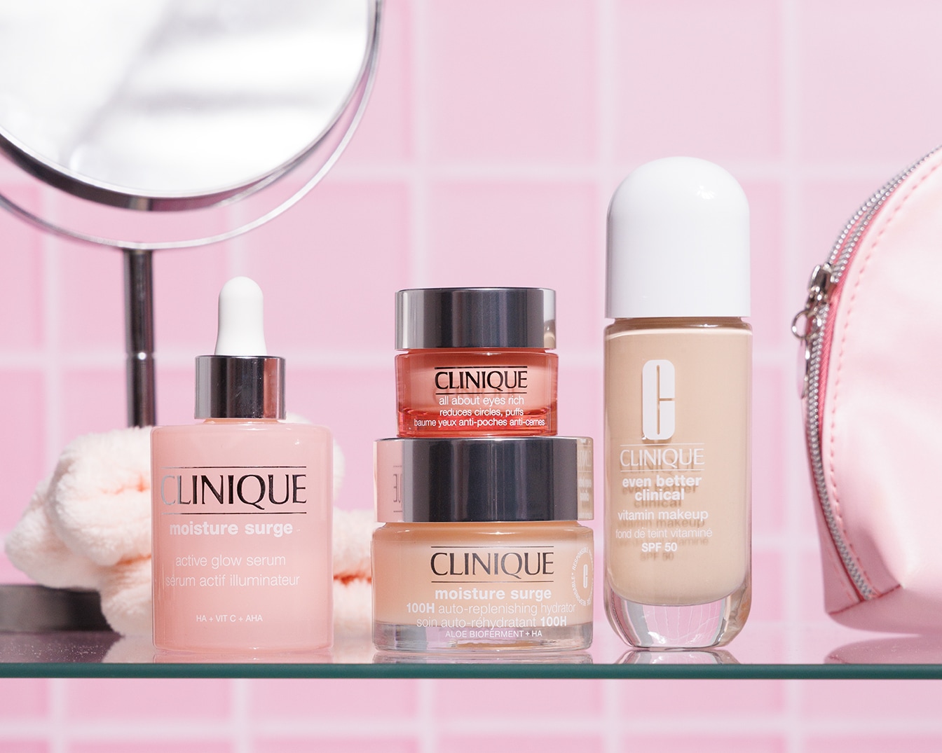 Una gamma di prodotti Clinique per la cura della pelle, tra cui siero, crema idratante e trucco, presentati in confezioni dai toni delicati di rosa e beige.