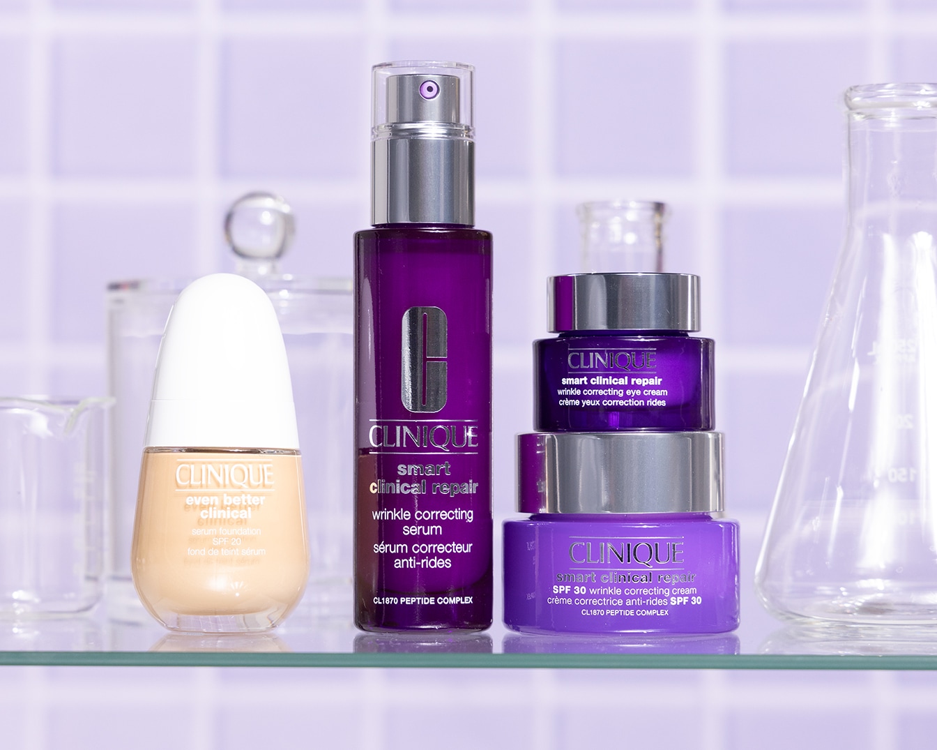 Una gamma di prodotti Clinique per la cura della pelle, tra cui siero correttore antirughe, crema per gli occhi e fondotinta siero SPF 20, presentati su uno scaffale di vetro.