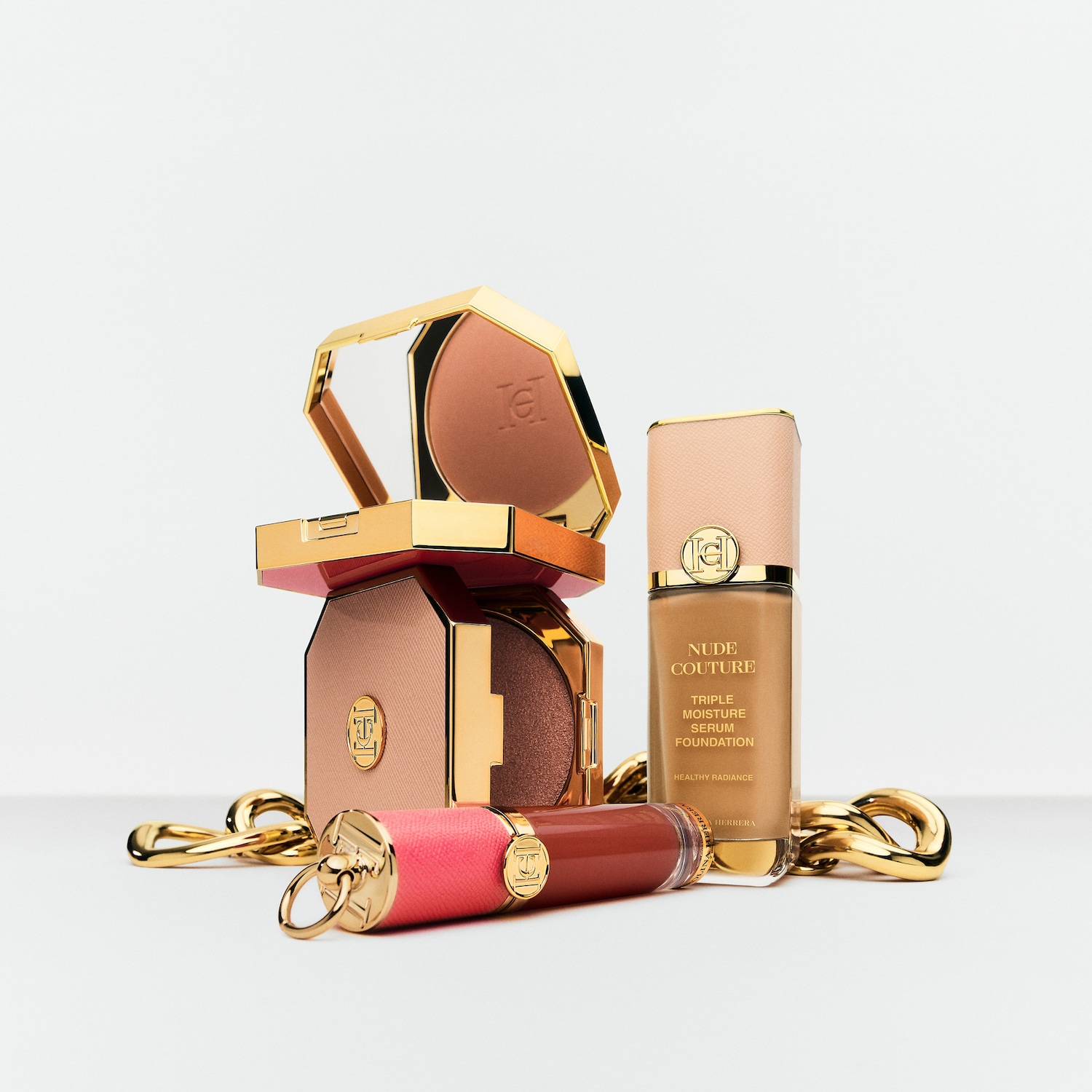 Entdecke Nude Couture Triple Moisture Serum Foundation für einen gesunden Teint, zusammen mit schimmerndem Bronzer und Lipgloss in einer goldenen Kette.