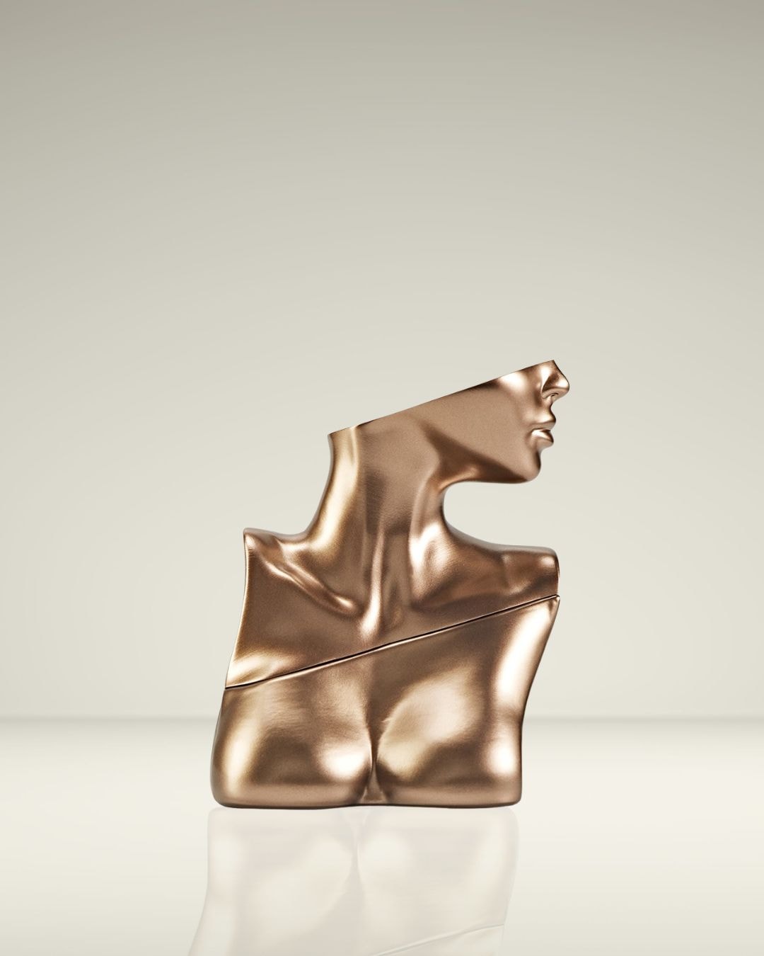 Gouden buste van een vrouwelijk torso, schuin afgesneden bij het hoofd, op een glanzende witte ondergrond.