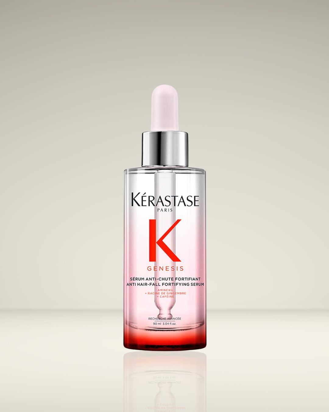 Voici le sérum anti-chute fortifiant Genesis de Kérastase, présenté dans un flacon transparent avec des accents rouges et un applicateur rose pâle.