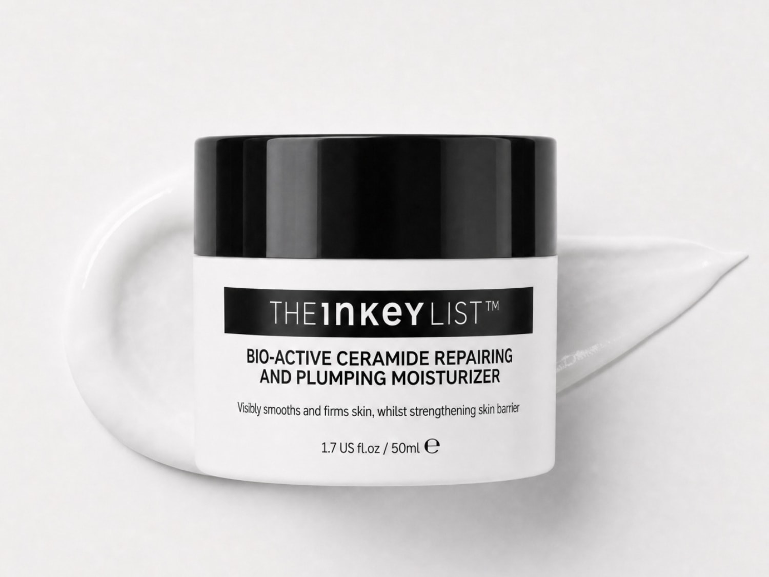 De Inkey List Bio-Active Ceramide Herstellende en Volumiserende Moisturizer in een witte pot met zwarte dop, omringd door een witte crème textuur, maakt de huid zichtbaar gladder en steviger en versterkt de huidbarrière.