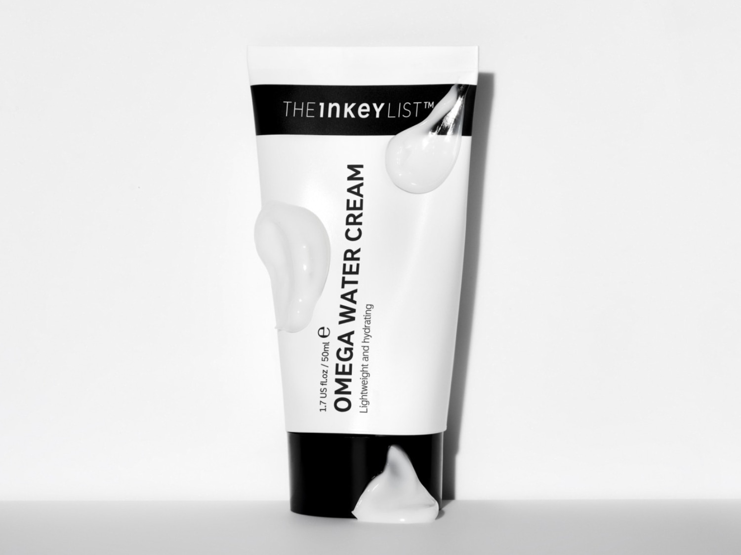 De Inkey List Omega Water Cream in een witte tube van 50 ml, met de tekst "Lightweight and hydrating" en een lichte, waterige textuur die uit de tube druipt.