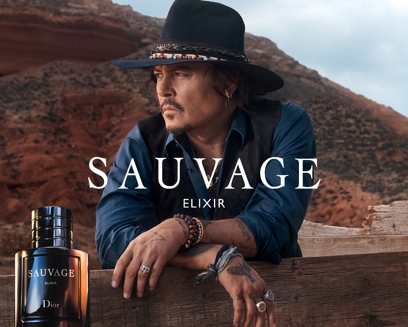 Dior Sauvage Elixir, gepresenteerd door Johnny Depp, toont een donkere flacon met de merknaam tegen een ruige woestijnachtergrond.