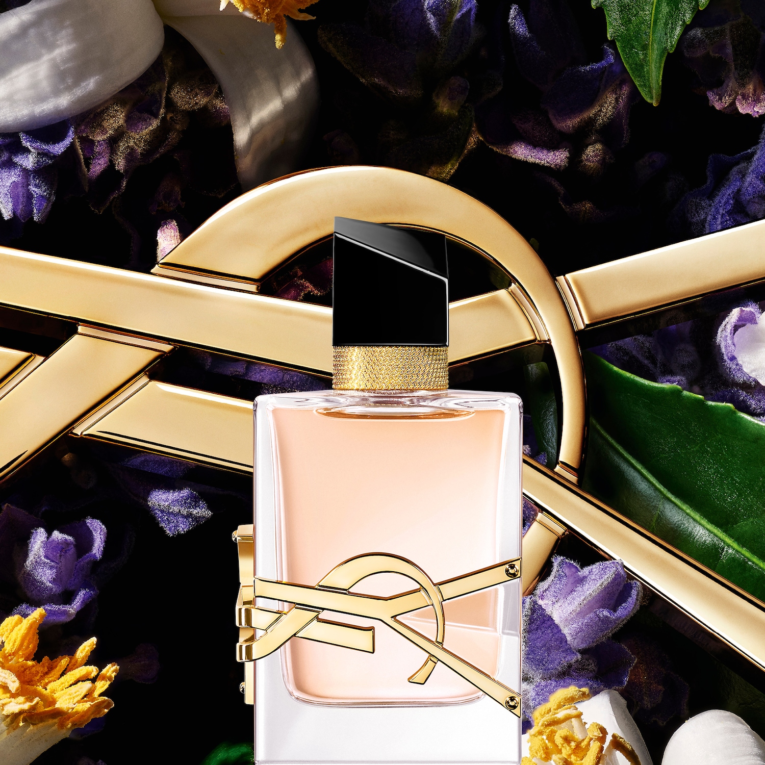 Découvrez le parfum Yves Saint Laurent, présenté dans un flacon carré élégant avec le logo doré emblématique, sur un fond floral luxuriant.