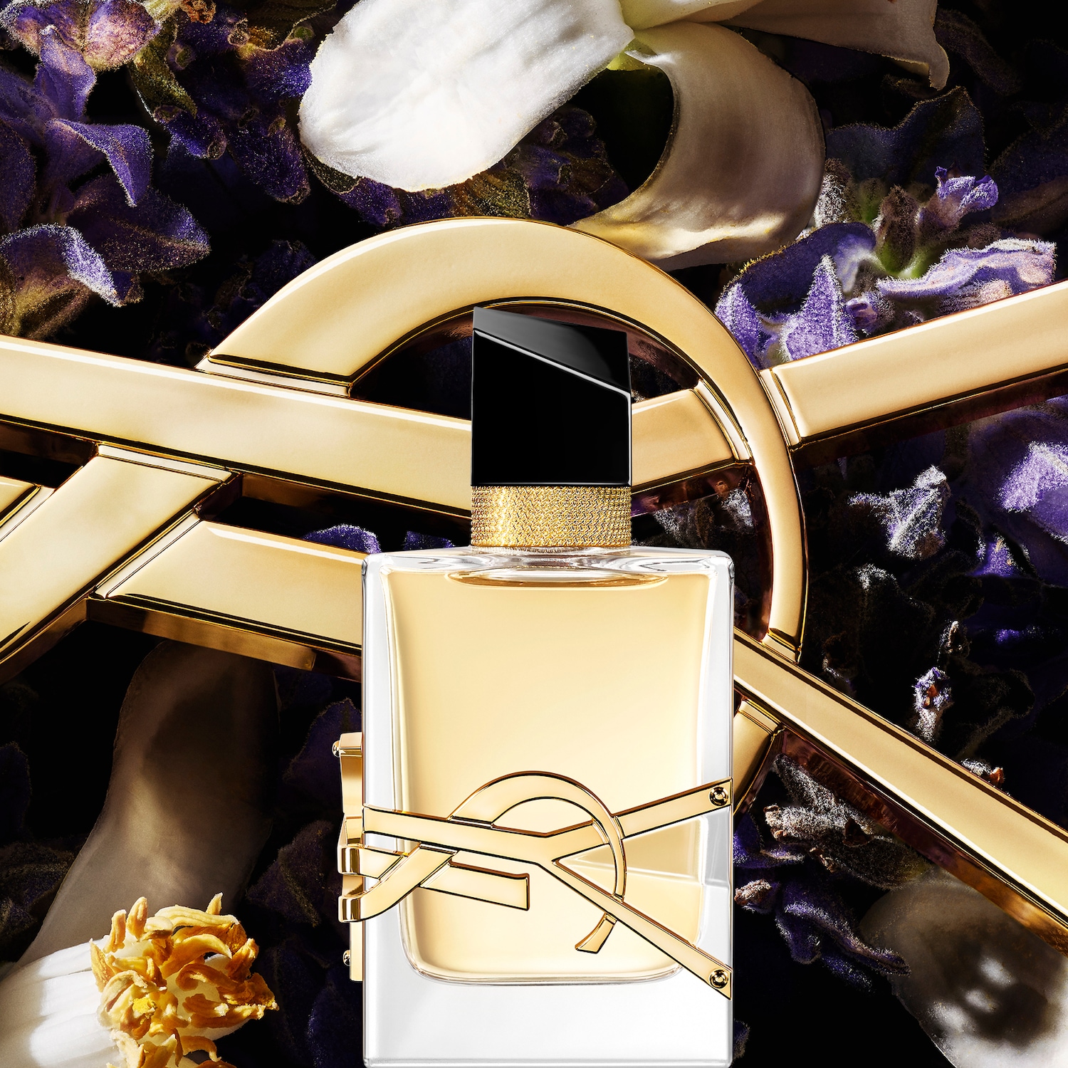 Découvrez le parfum Yves Saint Laurent, présenté dans un flacon élégant orné du logo doré emblématique, sur un fond floral violet et blanc.