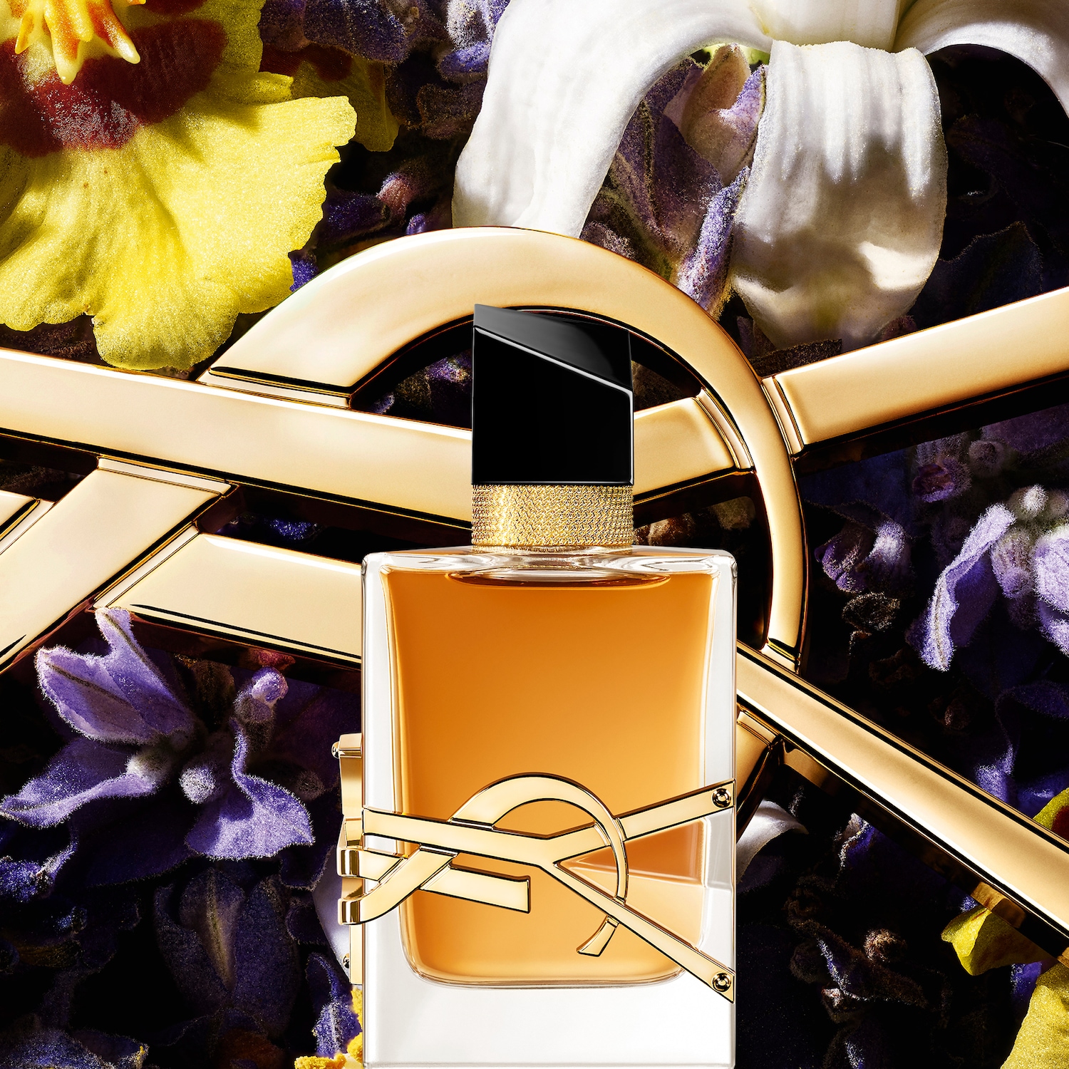 Découvrez le parfum Yves Saint Laurent, un nectar ambré capturé dans un flacon orné du logo iconique, sur un fond floral vibrant.