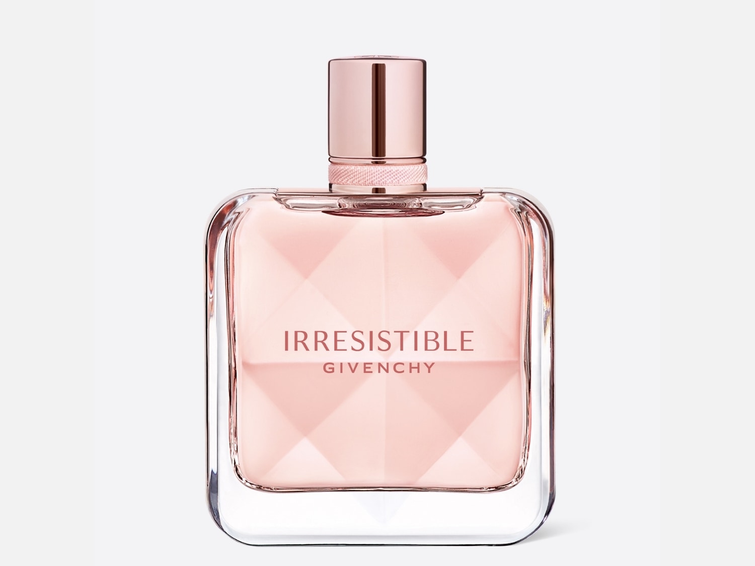 El frasco de perfume Irresistible de Givenchy tiene un jugo rosa pálido y está encerrado en un frasco de vidrio transparente con una tapa rosa metálica.
