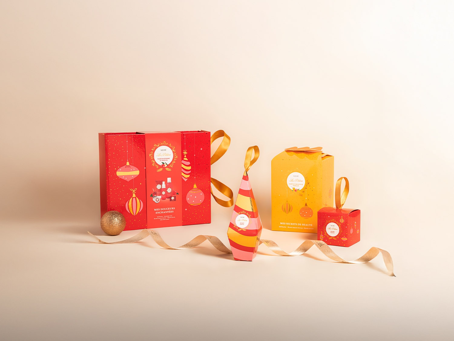 Découvrez les coffrets cadeaux Nocibé Les Délices, un assortiment de produits de beauté dans des emballages festifs rouge et or.