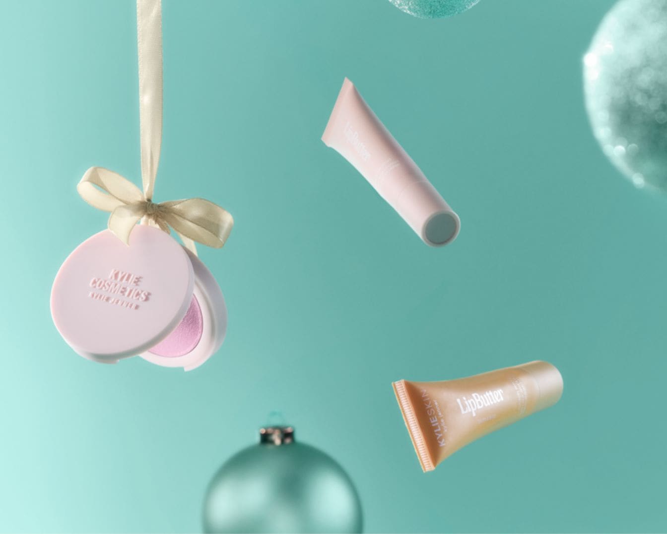 Ozdoba na vianočný stromček Kylie Cosmetics s ružovým púdrom a dva lesky na pery Lip Butter v ružovej a zlatej farbe.