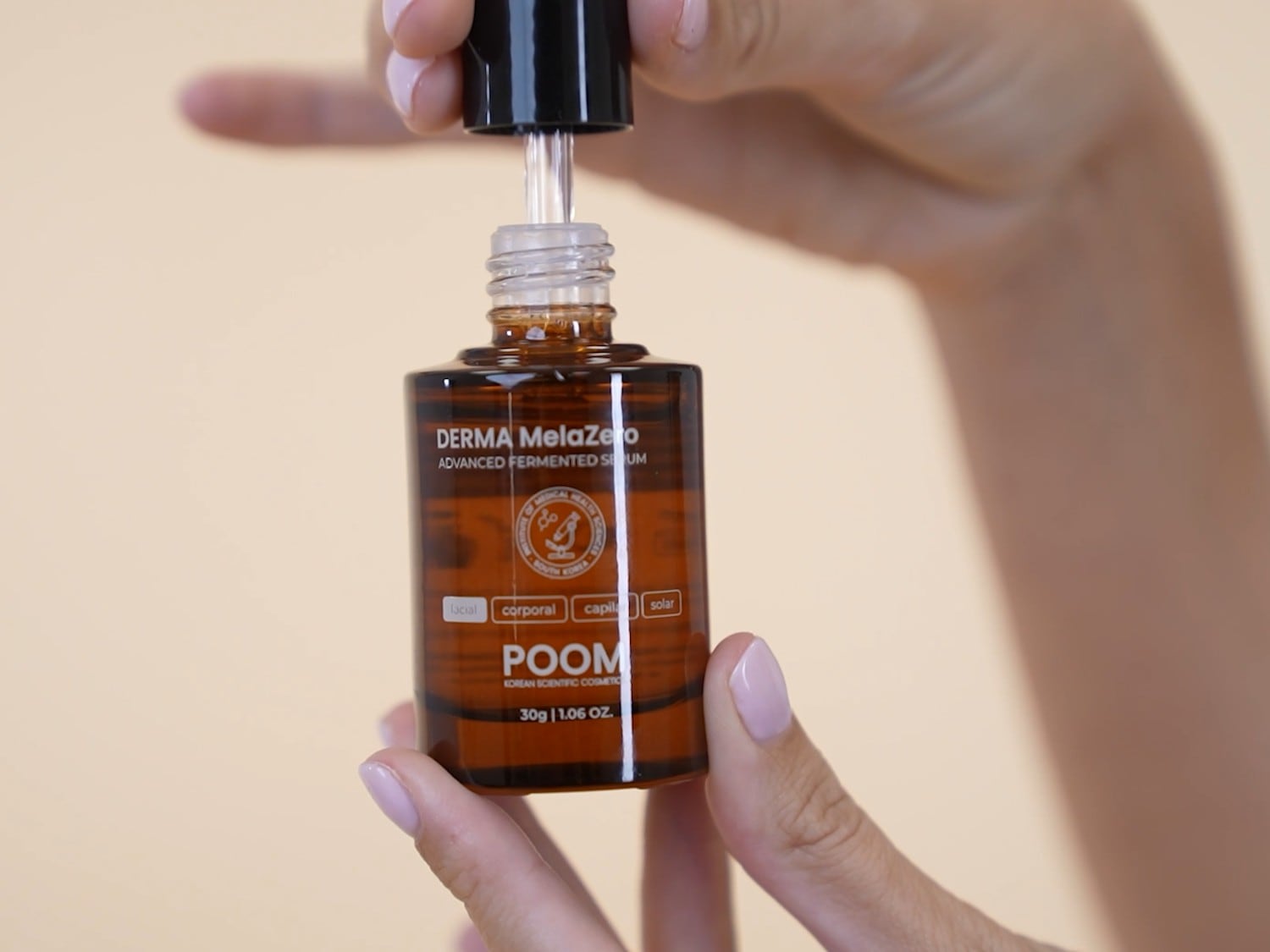 Aquí tienes el sérum fermentado avanzado Derma MelaZero de POOM, un cosmético científico coreano para el cuidado facial, corporal, capilar y solar, en un frasco marrón con pipeta.