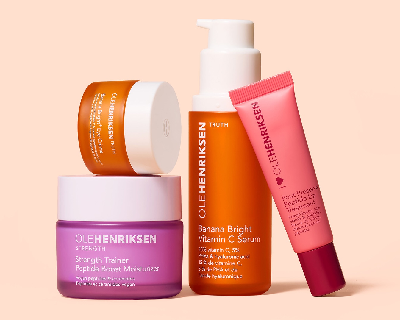 Vier Ole Henriksen huidverzorgingsproducten staan opgesteld, waaronder een oogcrème, een vochtinbrengende crème, een vitamine C serum en een lippenbehandeling.