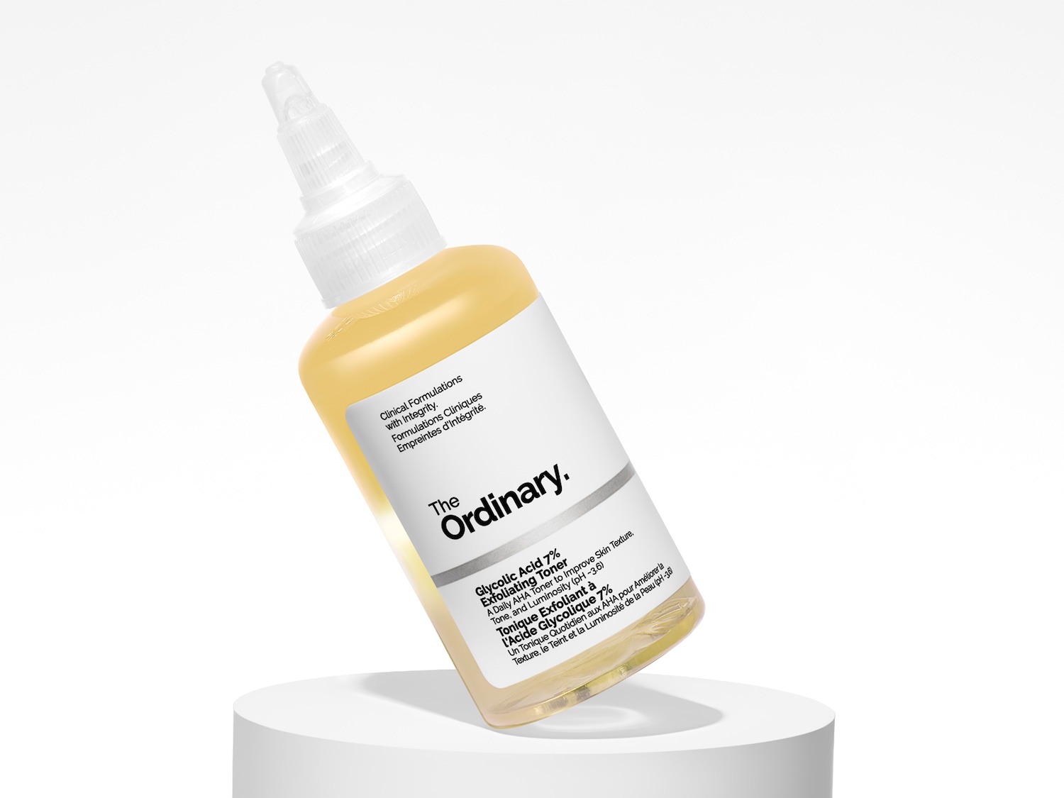 Der The Ordinary Glycolic Acid 7% Exfoliating Toner in einer durchsichtigen Flasche mit weißem Etikett steht auf einem weißen Display.