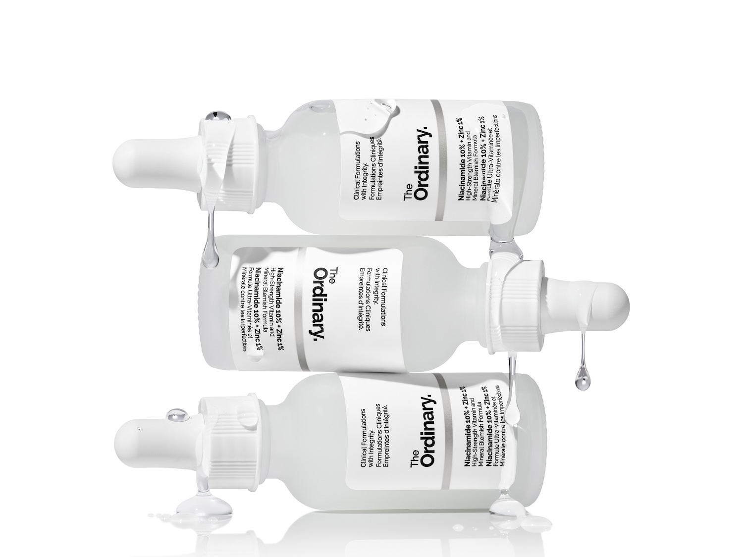 Drei Flaschen The Ordinary Niacinamid 10% + Zink 1% Serum liegen übereinander gestapelt vor weißem Hintergrund.