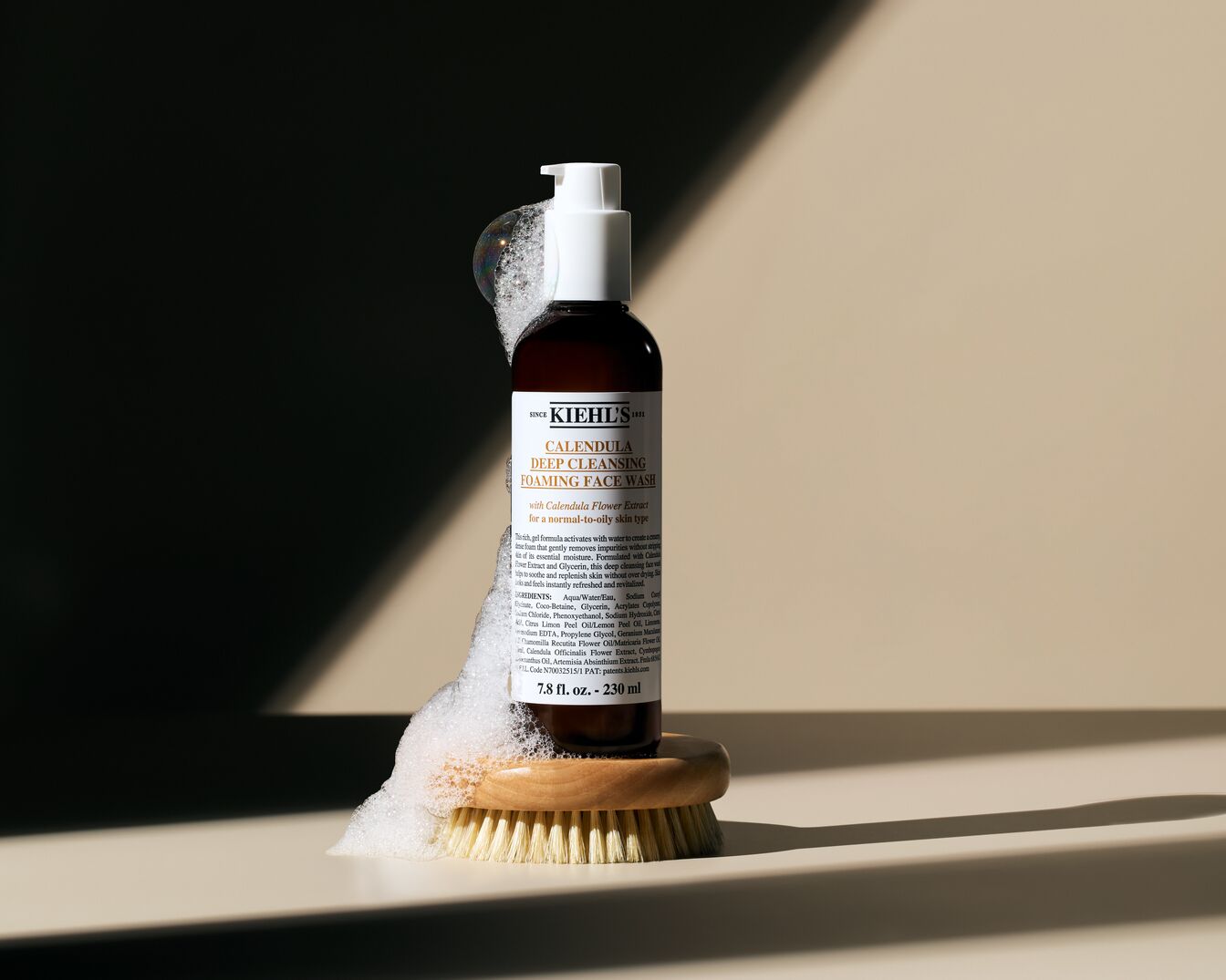 A Kiehl's Calendula mélytisztító habzó arclemosója barna üvegben, fehér pumpával, ecseten habbal, normál és zsíros bőrre.