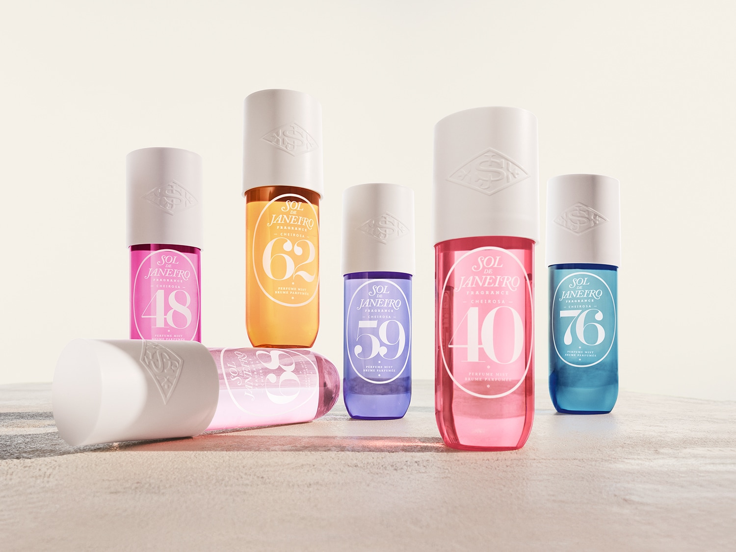 Eine Duftspray-Kollektion von Sol de Janeiro in verschiedenen Farben, darunter Rosa, Orange, Lila, Rot und Blau, die jeweils mit einer Nummer von 48 bis 76 gekennzeichnet sind.