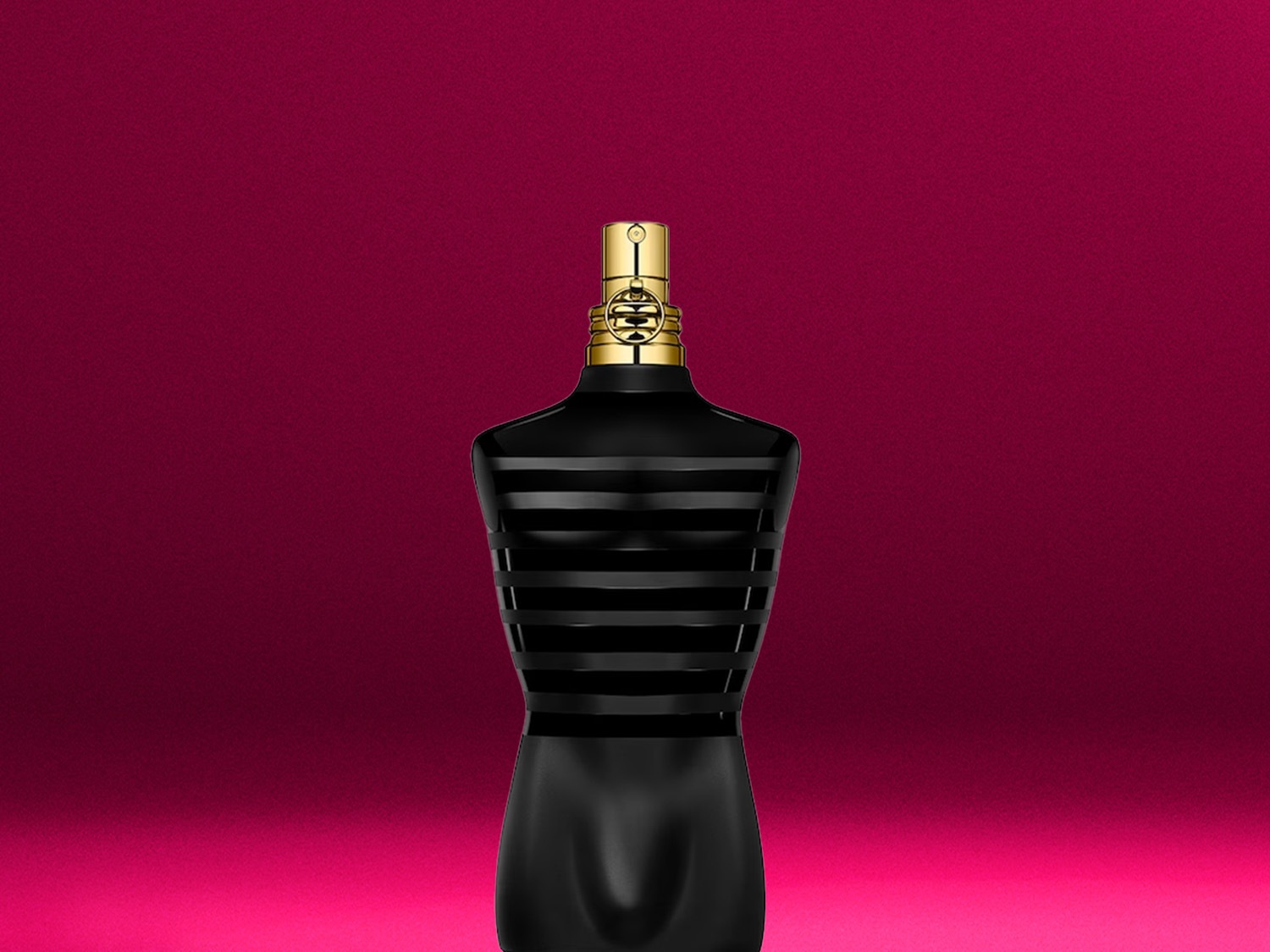 Schwarzer Flakon in Form eines Männeroberkörpers mit goldenem Verschluss vor einem pinkfarbenen Hintergrund.
