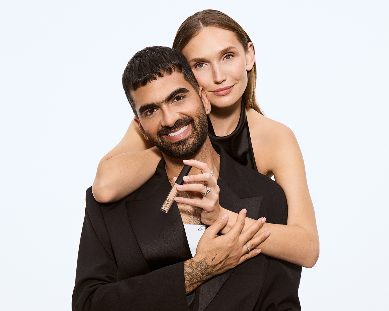 Anna hält den NARS Radiant Creamy Concealer, während sie Arya umarmt, beide lächeln.