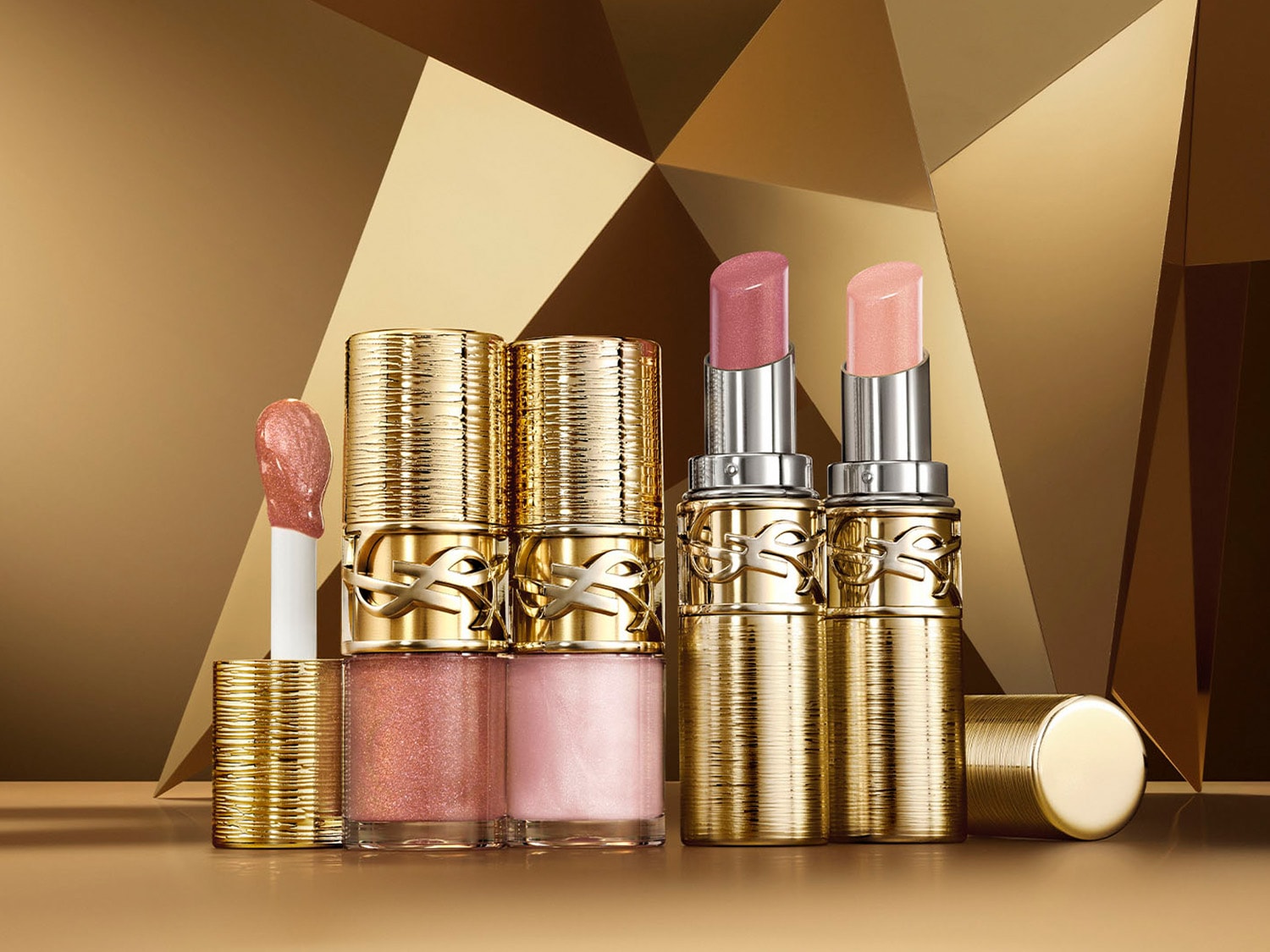 Zestaw błyszczyków i pomadek YSL w złotych opakowaniach, idealny do makijażu ust z efektem blasku.