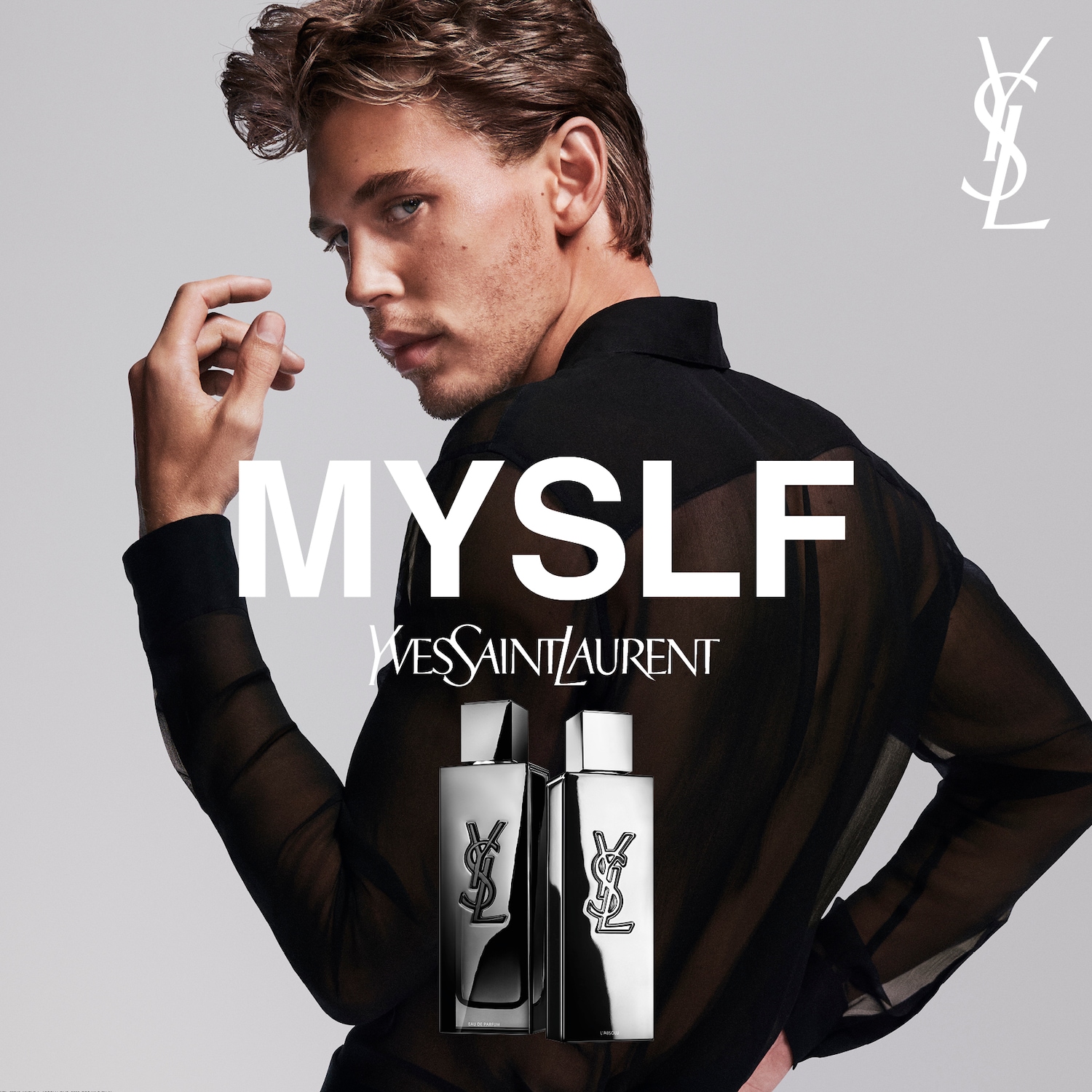 Na szarym tle widać mężczyznę w czarnej koszuli, obok niego flakon perfum MYSLF Yves Saint Laurent z logo YSL.
