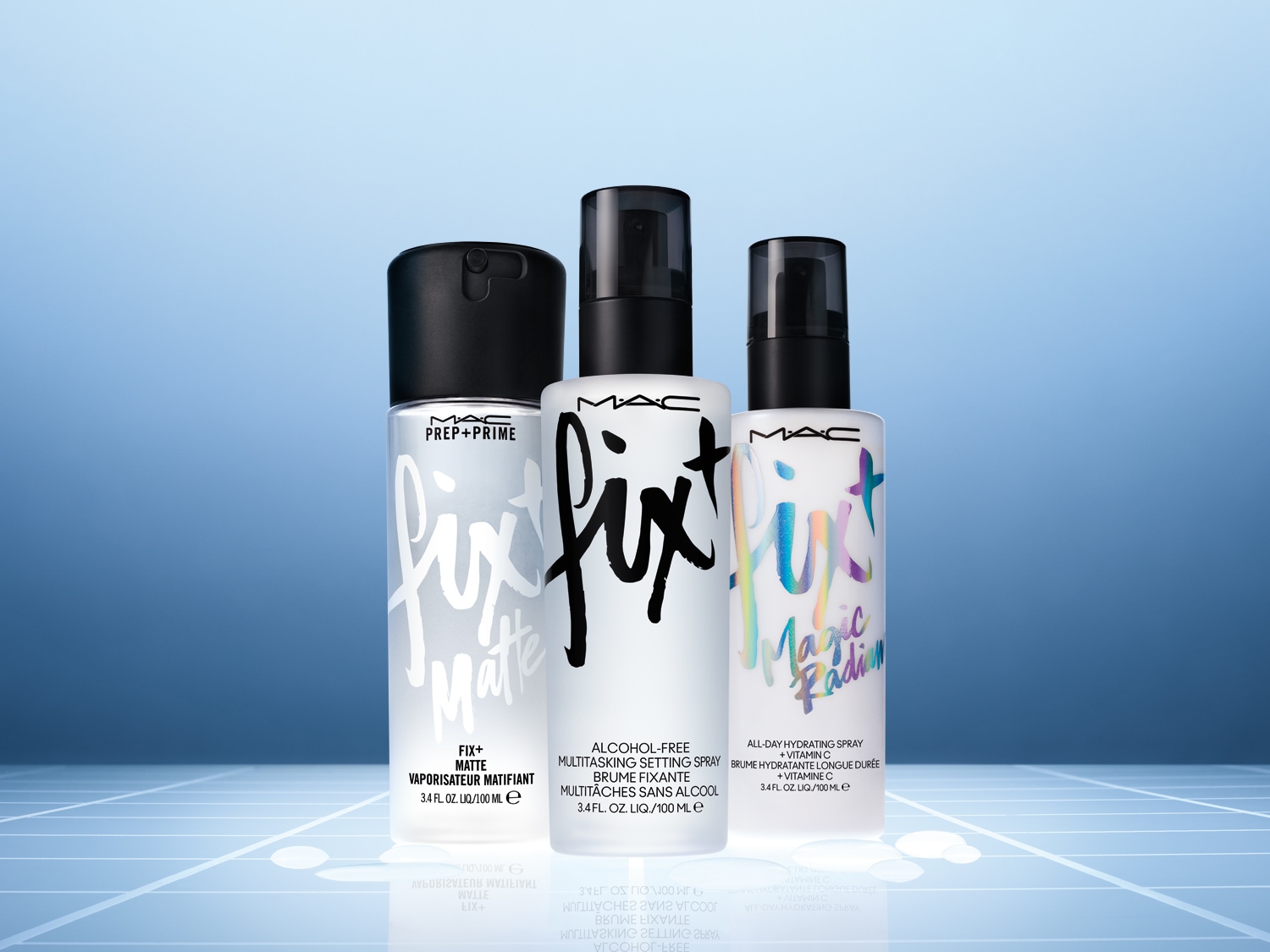 Drei verschiedene MAC Fix Sprays in weißen Flaschen mit schwarzen Sprühköpfen vor blauem Hintergrund.