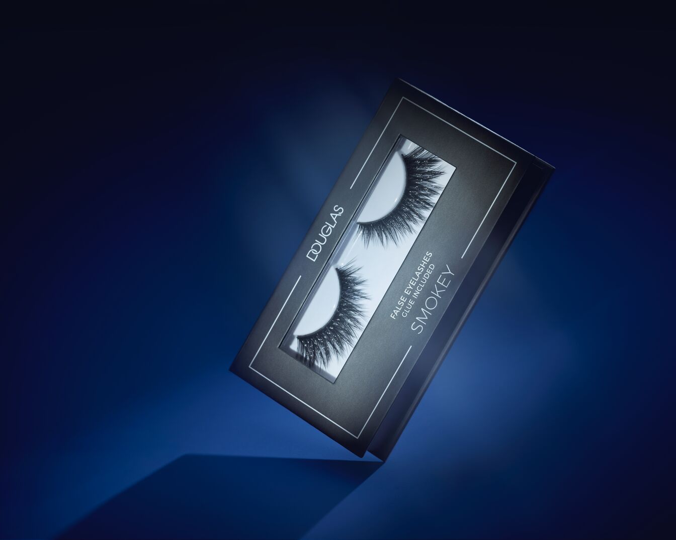 Douglas Falsche Wimpern Smokey mit Kleber in einer schwarz-silbernen Verpackung, um einen dramatischen Augenaufschlag zu erzielen.