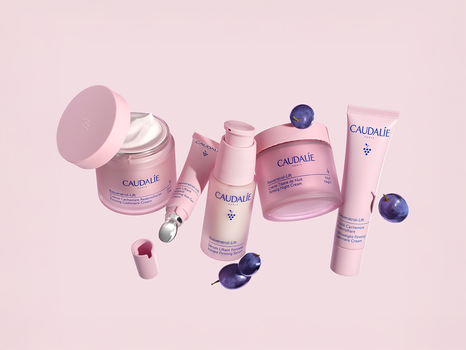 Entdecke die Resveratrol-Lift-Serie von Caudalie mit straffender Kaschmir-Creme, Augenpflege, Nachtcreme und Serum in zarten Rosatönen, ergänzt durch dunkle Pflaumen.